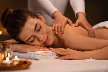 Obraz na płótnie Canvas Joyful girl getting body massage with aromatherapy at spa