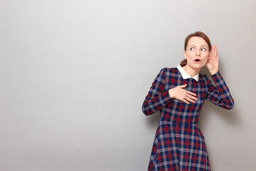 Portrait of curious girl placing hand near ear and eavesdropping