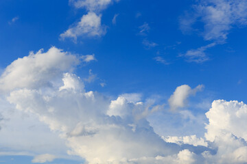 White clouds against the blue sky background in sunny cloudy summer day.
