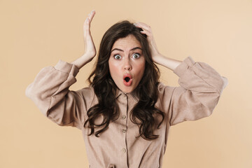 Image of shocked brunette woman posing and grabbing her head