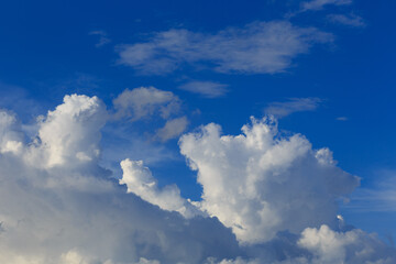 White clouds against the blue sky background in sunny cloudy summer day.