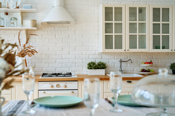 Serving for dinner on kitchen table. Light kitchen background interior.