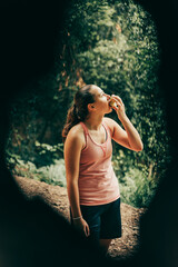 Girl eating an apple through a tree.