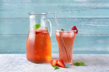 A jar and glass with cold summer strawberry drink