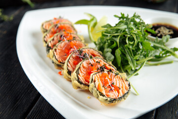 Deep-fried salmon rolls with arugula and soy sauce