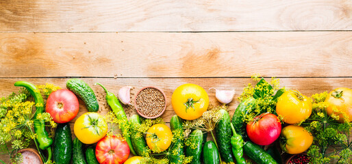 Harvesting seasonal vegetables, cucumbers, tomatoes, peppers and spices on a wooden background