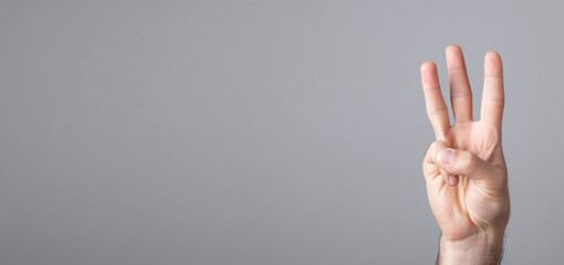 Male hand showing three fingers.