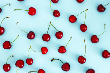 Cherry berries on a blue background top view, flat lay, pattern. Berry background for creativity.