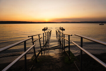 Obraz premium Bridge of a lake with mountains in a sunset