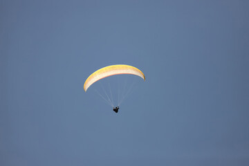 Tourist fly a paraglider with a yellow parachute