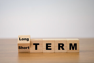 Flipping od wooden cube block for change short term to long term. Business investment concept.