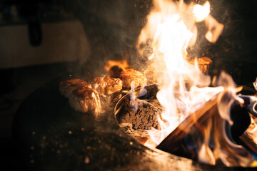 Steaks are grilled in the flames of fire.