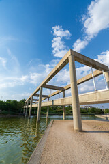 Angular view of concrete bridge over canal, with blue sky, in Juan Carlos I park in Madrid, Spain, vertically