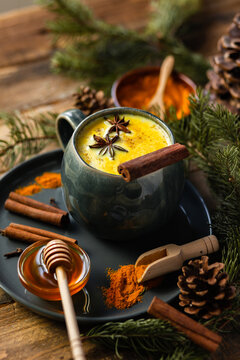 Golden milk, turmeric latte in grey mug. Spicy traditional Indian drink. Healthy natural healing curcuma beverage, alternative medicine. Close up, front view, rustic wooden background