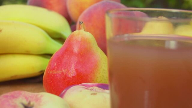Panorama from the fresh ripe fruits to the glass with multifruit delicious juice