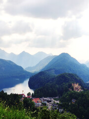 Misty day in the Bavarian Alps near Fussen, Germany. Alps and lakes in a summer day in Germany. Taken from the hill next to Neuschwanstein castle. View of the Hohenschwangau castle, Bavarian Alps