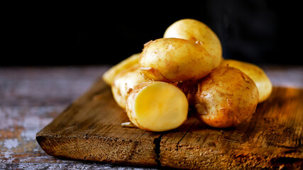 Selective focus. Young raw potato on a wooden surface. Fresh potato harvest.