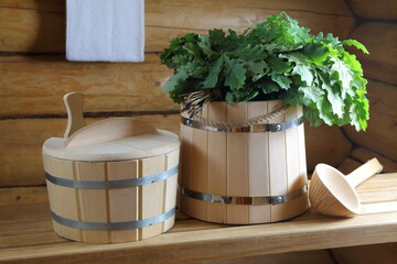 Traditional wooden sauna accessories and fresh oak broom. 