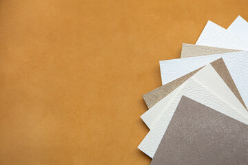 Background of genuine light brown leather and leather samples of different colors
