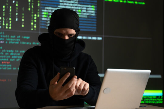 Hacker uses a mobile phone to hack the system. Stealing personal data and money from Bank accounts. The concept of cyber crime and hacking electronic devices