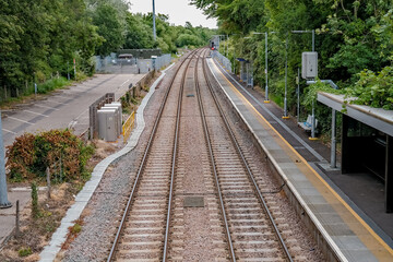Fototapeta premium View down the north heading railway line in the Norfolk village of Brundall captured from the pedestrian bridge over the track