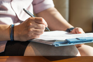 man hand with pencil writing on document.