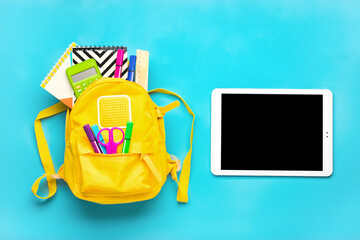 Back to school, education concept. Yellow backpack with school supplies Notebook, pens, ruler, calculator, scissors, tablet isolated on blue background Top view Copy space Flat lay composition Mock up