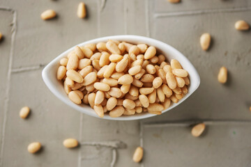 shelled pine nuts in a white bowl
