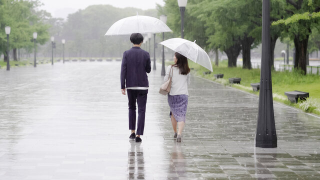雨の日に傘を差してデートするカップル