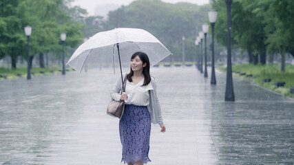 雨の日に通勤するビジネスウーマン　手持ち撮影