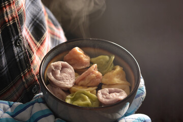 Russian hot dumplings with meat natural colored in hands closeup. Russian traditional food pelmeni