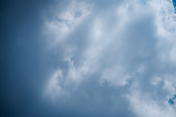 Bright sky in the daytime with white clouds and sunlight shining down.