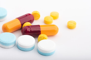 Heap of assorted various medicine tablets and pills different colors on white background. Copy space.