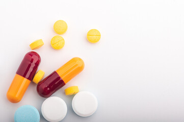 Heap of assorted various medicine tablets and pills different colors on white background. Copy space.