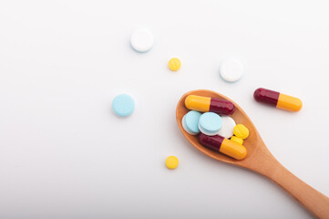 medicine herbal capsules pill in wooden spoon isolated on white background.