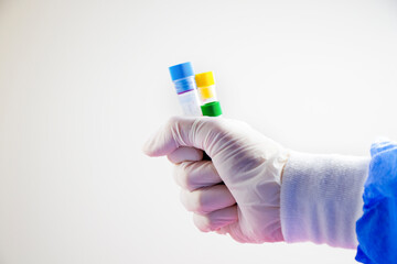 Blood test tubes in doctor hand and glove on the white background, studio shoot.