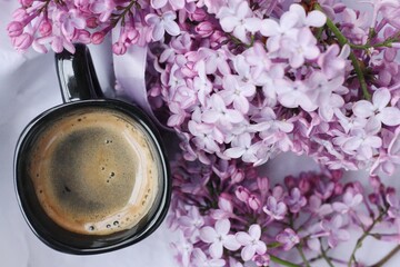 Beautiful bouquet of lilac and a Cup of Americano coffee