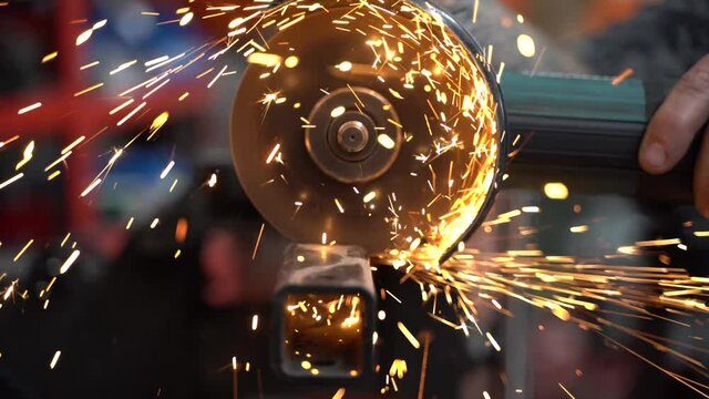 sierra radial cortando una viga de metal negra y sacando chispas