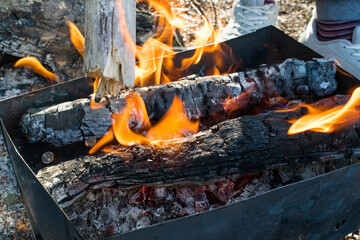 A fire is burning, a barbecue, charred logs