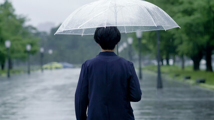 雨の日に傘を差して出かける男性　手持ち撮影