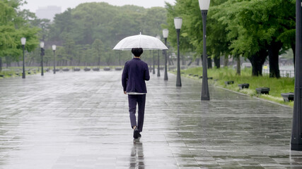 雨の日に傘を差して出かける男性　手持ち撮影