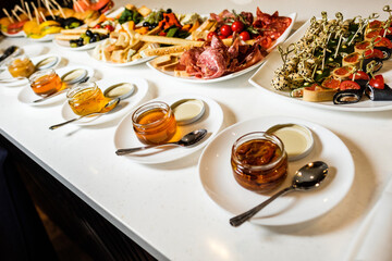 tasty appetizers with honey on a white table
