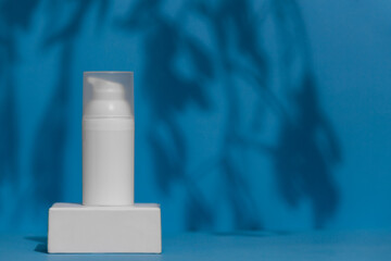 White skin care product tube on blue background, advertisement concept. Skin treatment container with place for brand.