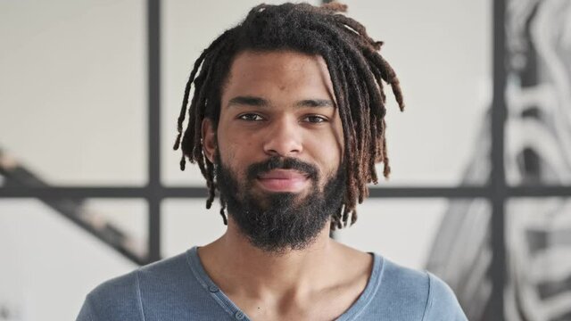 A handsome young african american man is opening his eyes and looking to the camera at home