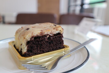 Chocolate brownies on a white plate in a coffee shop.