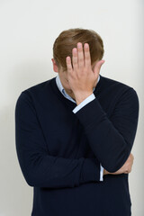 Portrait of stressed man with blond hair having headache