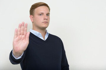 Portrait of man with blond hair showing stop gesture