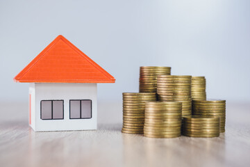 Orange roof houses and coins heap, saving money for new home purchases or loans to plan your real estate investment business. Home insurance Real estate Mortgages Borrowings Rental.