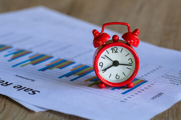 The red alarm clock rests on a graph of important time every second. Concepts for business deadlines, schedules and urgency. Business planning Important time management.
