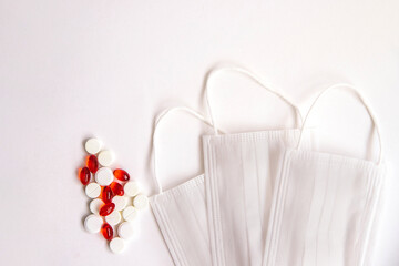 Medical mask and tablets with capsules on a white background. Medical topic.